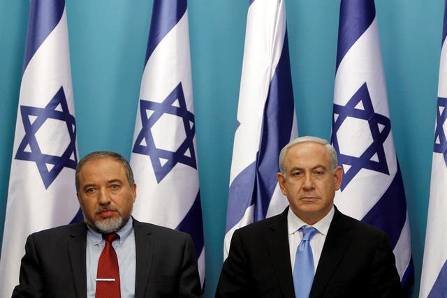Israel's Prime Minister Benjamin Netanyahu (R) sits next to then Foreign Minister Avigdor Lieberman in 2012
