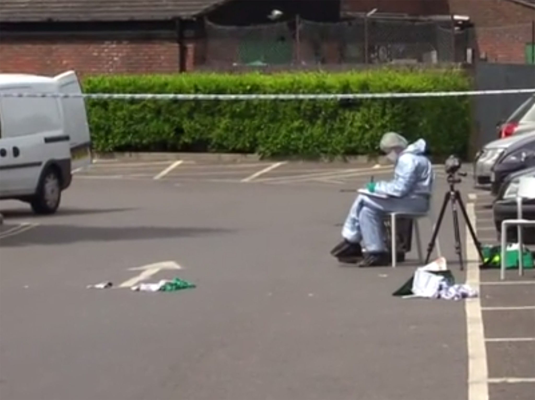 Forensic teams analysing bloody clothes at the scene of the stabbing