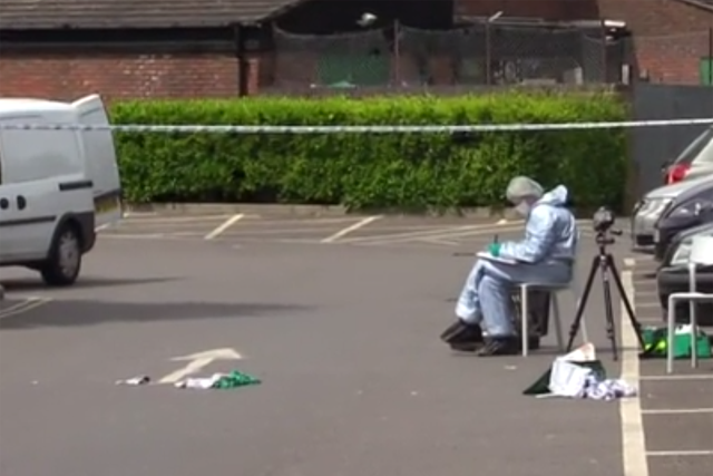 Forensic teams analysing bloody clothes at the scene of the stabbing