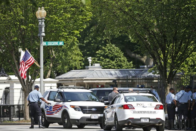 Police gather at the White House gates following the shooting
