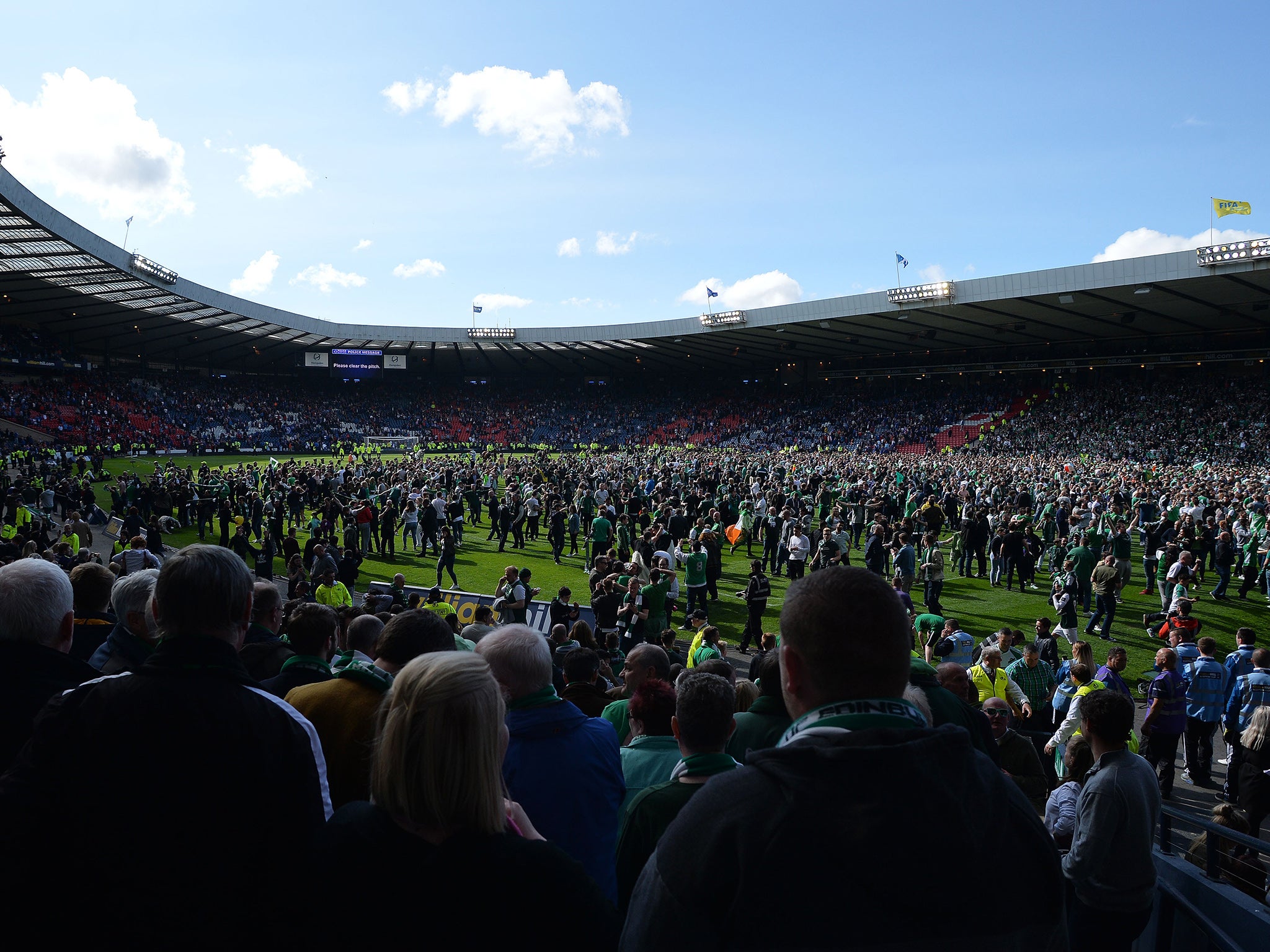 Fans invade the Hampden Park pitch after the game
