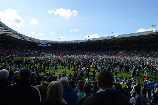 Fans invade the Hampden Park pitch after the game