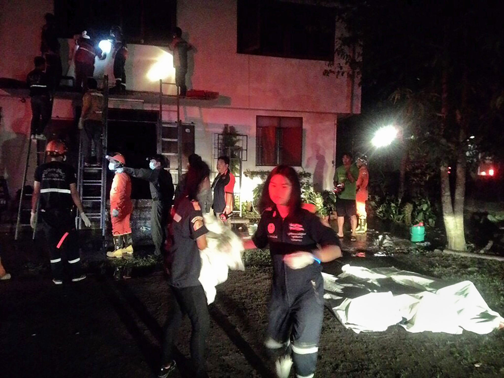 Thai firefighters and rescue workers collect the bodies of Thai elementary girl students after a fire broke out at a school dormitory in Chiang Rai province, northern Thailand, early 23 May 2016