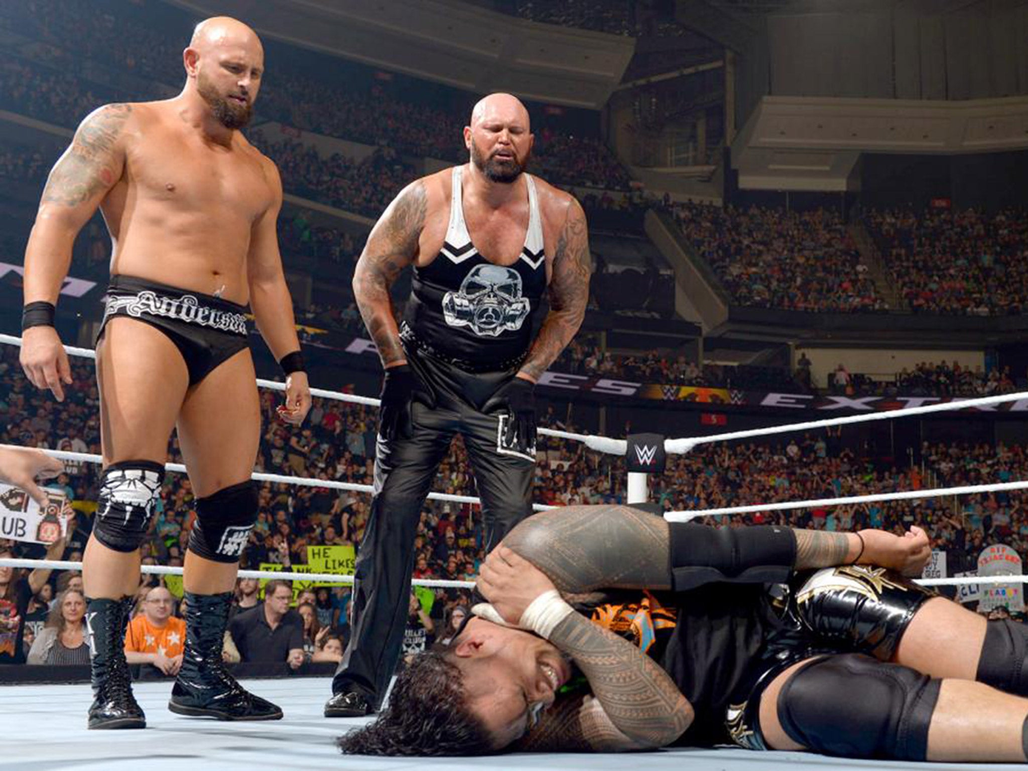 Karl Anderson and Luke Gallows stand tall over Jimmy Uso