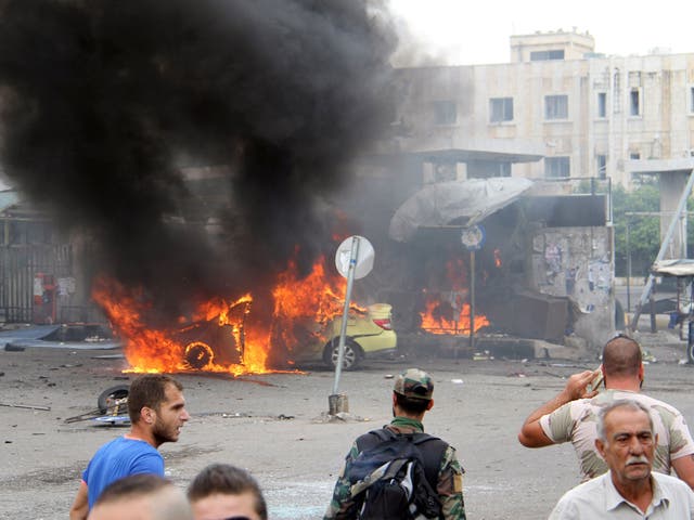 A Syrian army soldier and civilians inspect the damage after explosions hit the Syrian city of Tartous, in this handout picture provided by SANA on May 23, 2016