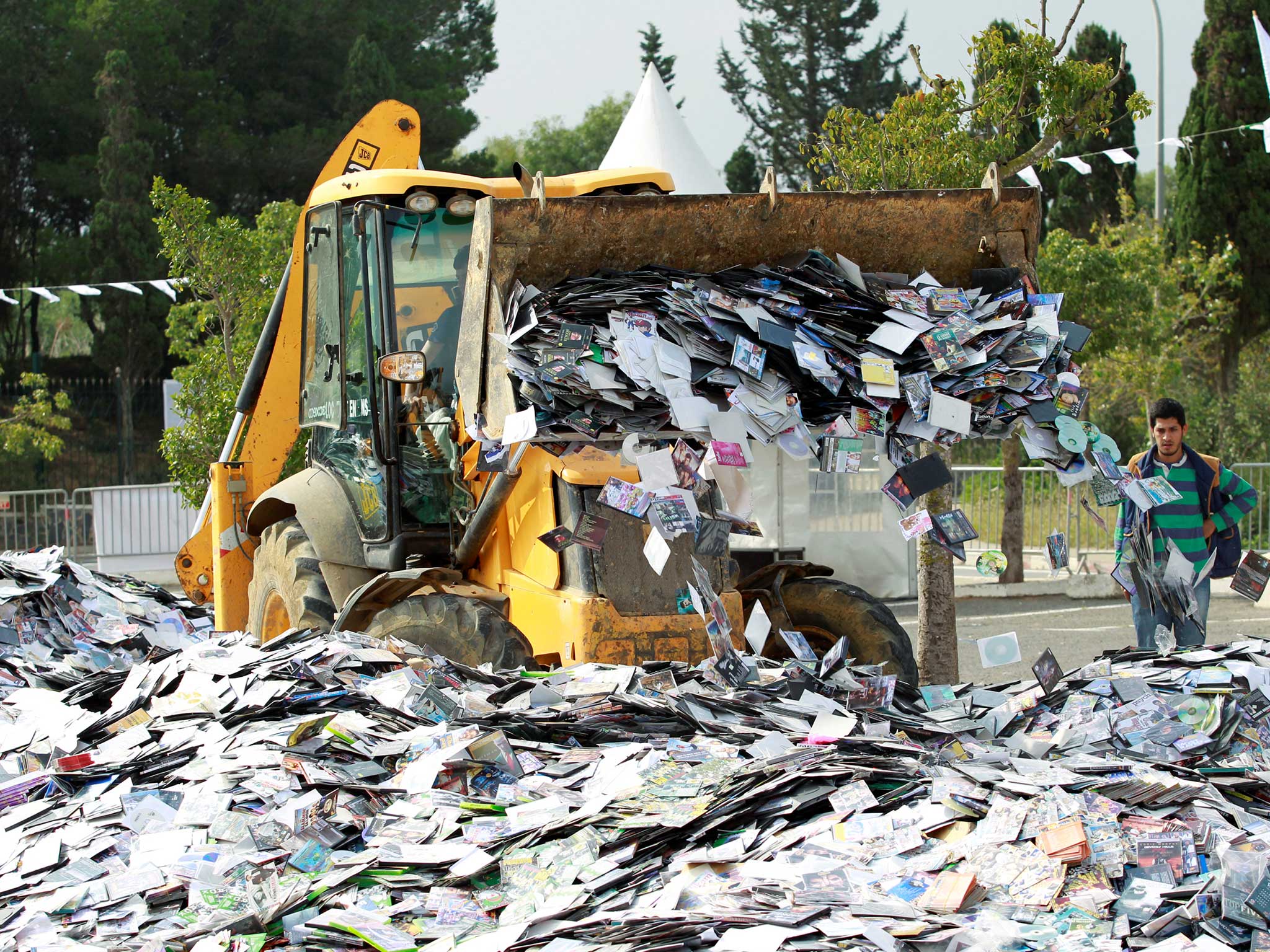 A crane destroys over one million pirated music, movie and software CDs and DVDs in a campaign against piracy organised by the government in Algiers, Algeria