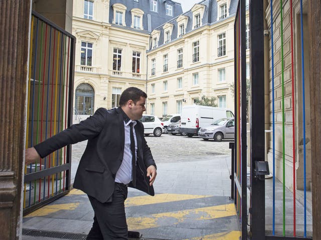 A guard closes the gate of Google's Paris headquarters after a raid