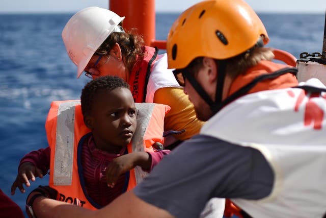 Rescuers take care of a child during a rescue operation at sea of migrants and refugees with the Aquarius, off the Libyan coast