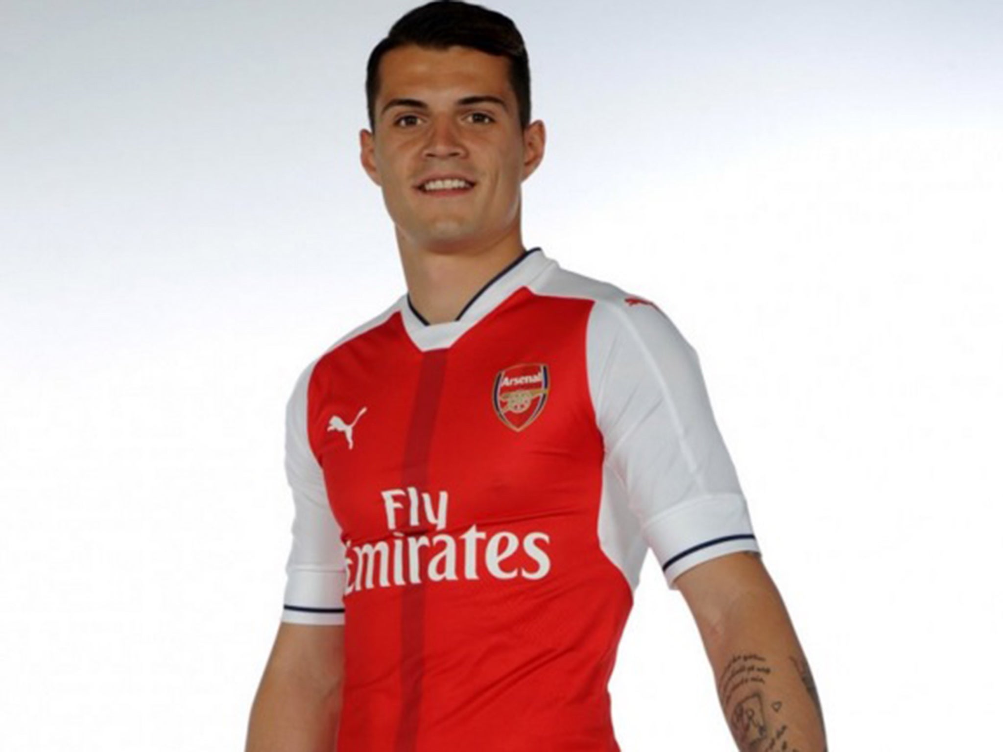 Granit Xhaka poses in an Arsenal shirt following completion of his transfer to the Premier League