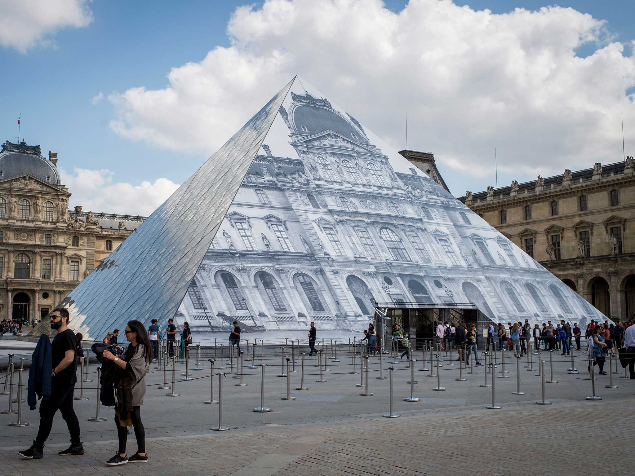 A view of the Pyramid of the Louvre museum covered with a gigantic black and white trompe l'oeil photo of the Louvre building by French artist JR in Paris. The exhibition 'Contemporary art JR at the Louvre' runs from 25 May to 27 June