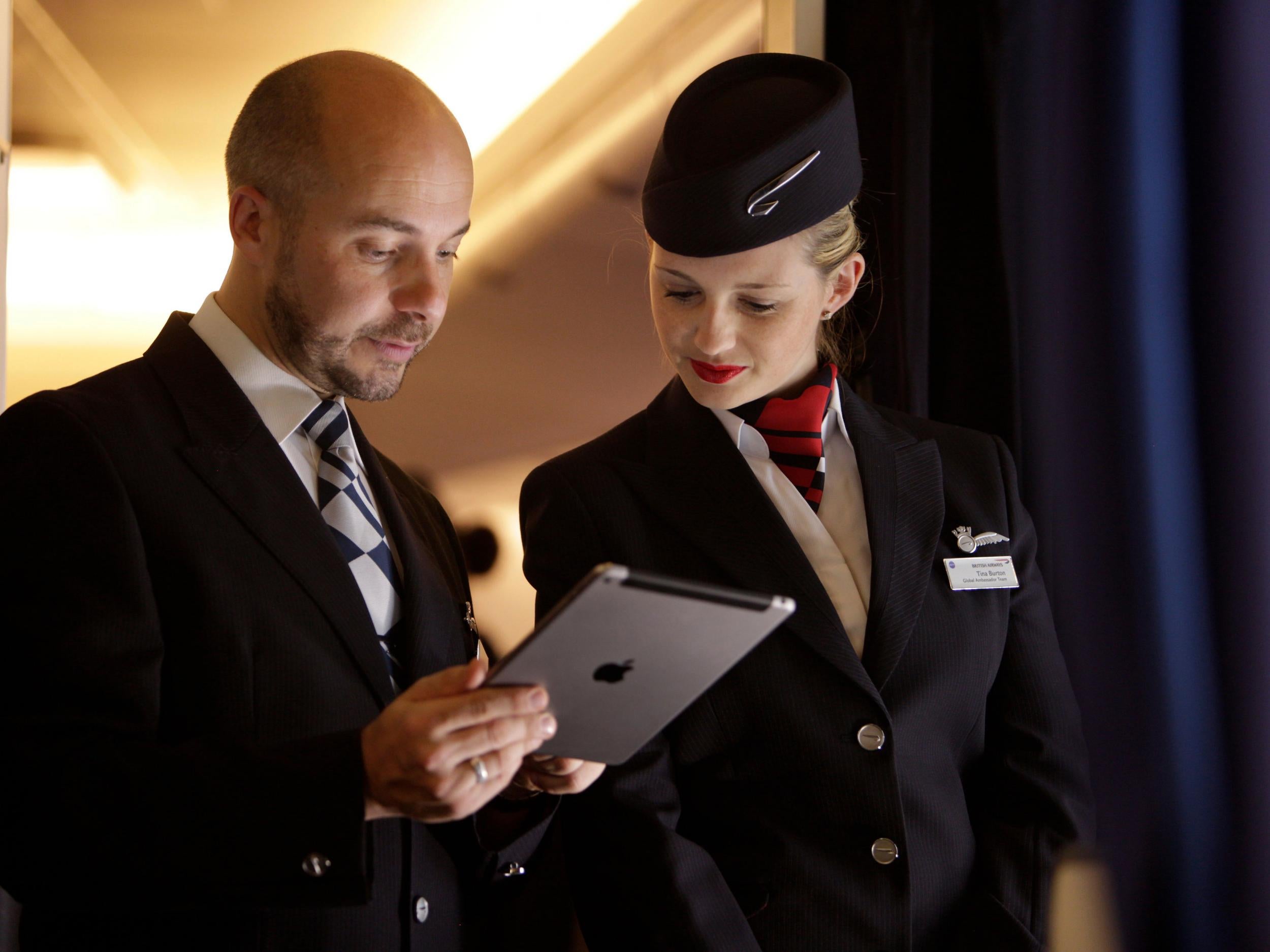 British Airways staff use an iPad to check the passenger list