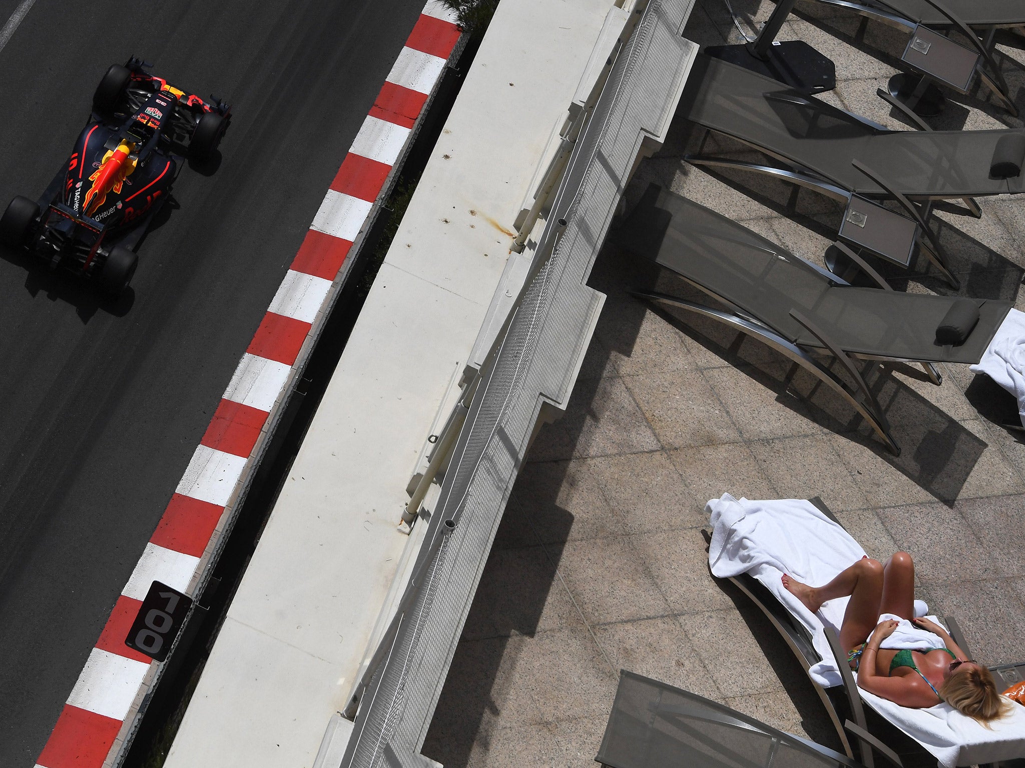 &#13;
A woman sunbathes as Ricciardo flashes past during practice &#13;