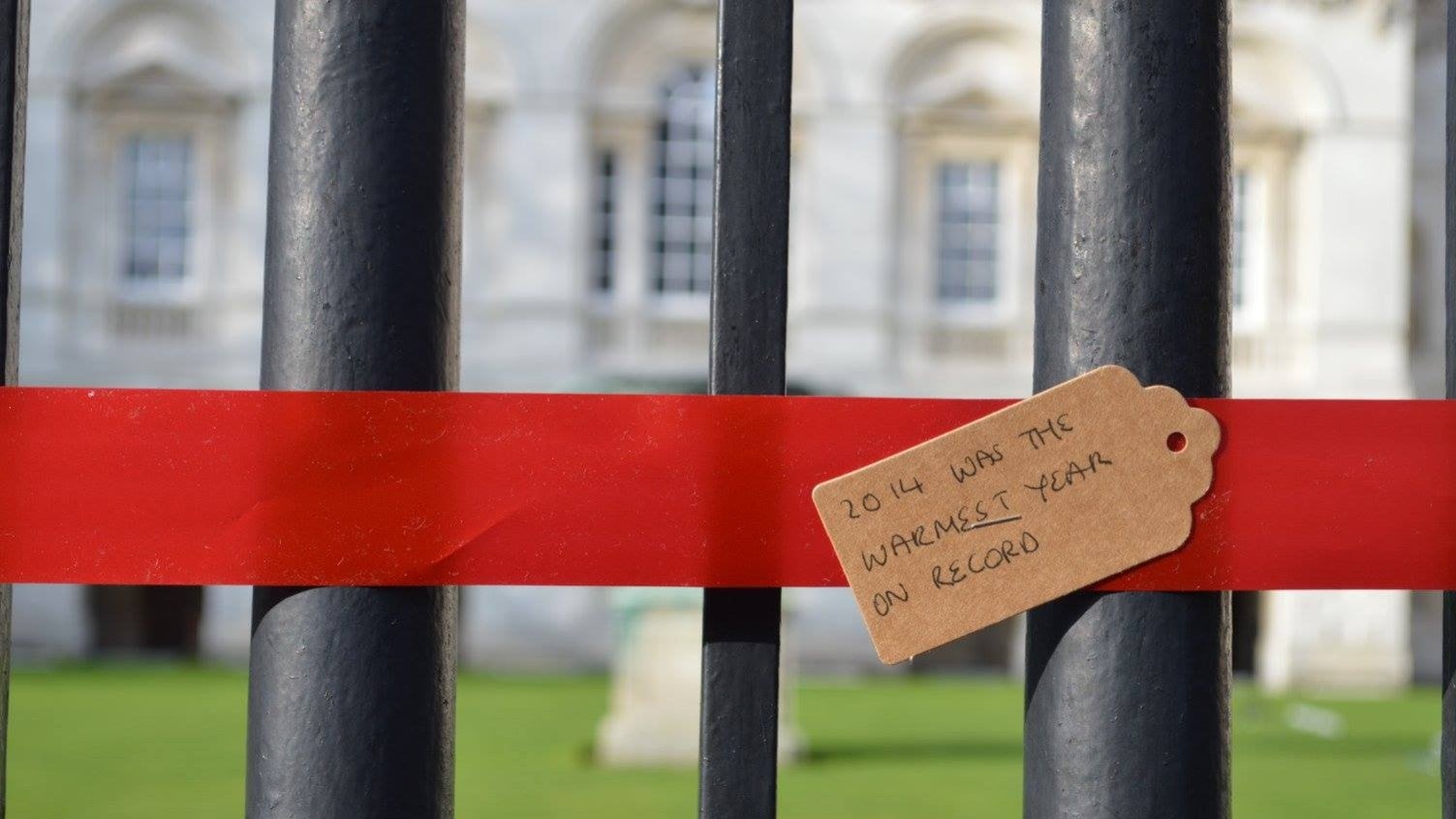Student protesters tie red ribbon around Cambridge University buildings to highlight the impact investments into fossil fuels is having (via Cambridge Zero Carbon Society/Facebook)