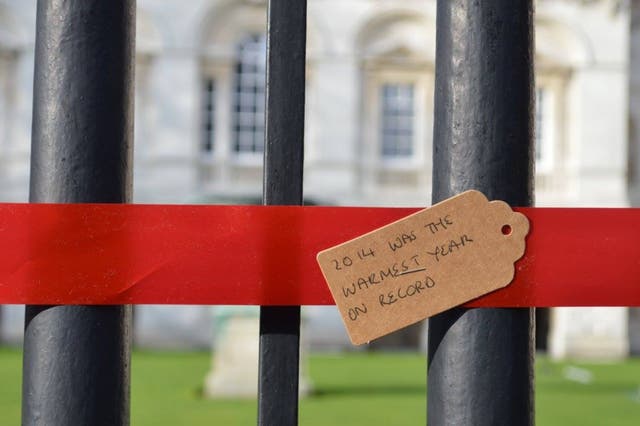 Student protesters tie red ribbon around Cambridge University buildings to highlight the impact investments into fossil fuels is having (via Cambridge Zero Carbon Society/Facebook)