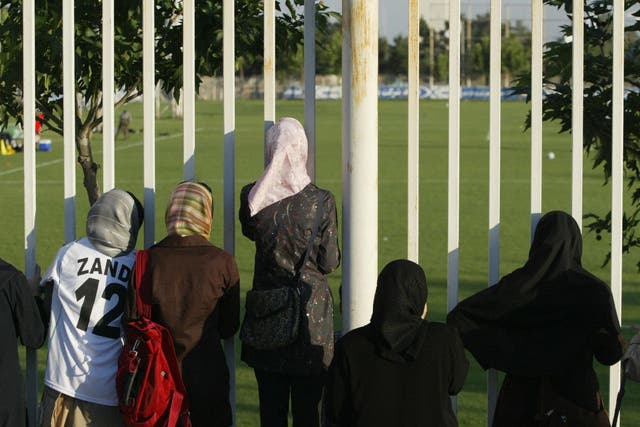 Iranian women watch a training session of Iran's national football team from behind a fence as females were not allowed to enter the stadium at Tehran's Azadi (Freedom) sport complex.