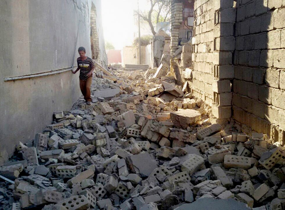 A man walks in the rubble of damaged house in Fallujah, 40 miles (65 kilometers) west of Baghdad
