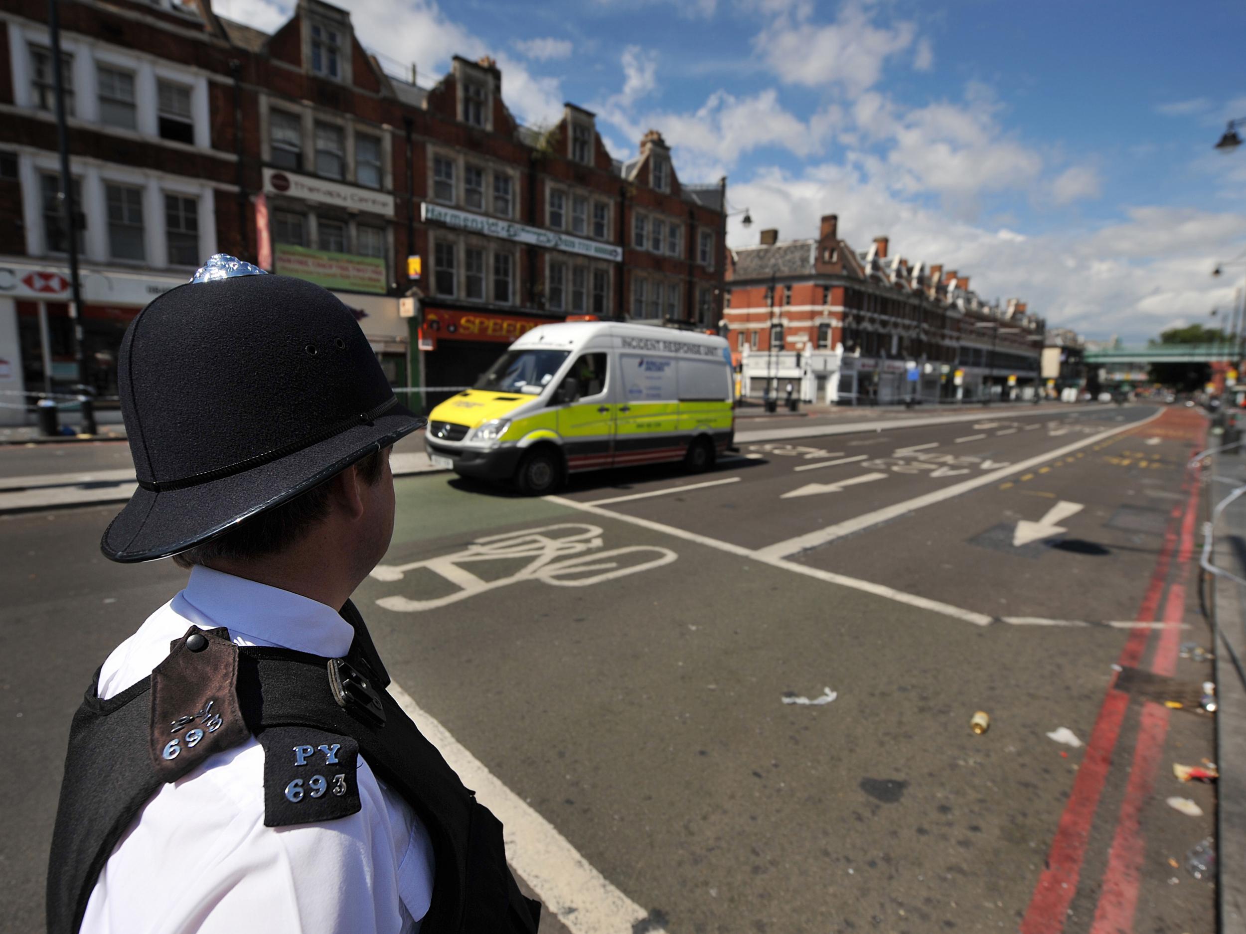 A police officer looks onto Brixton High Street