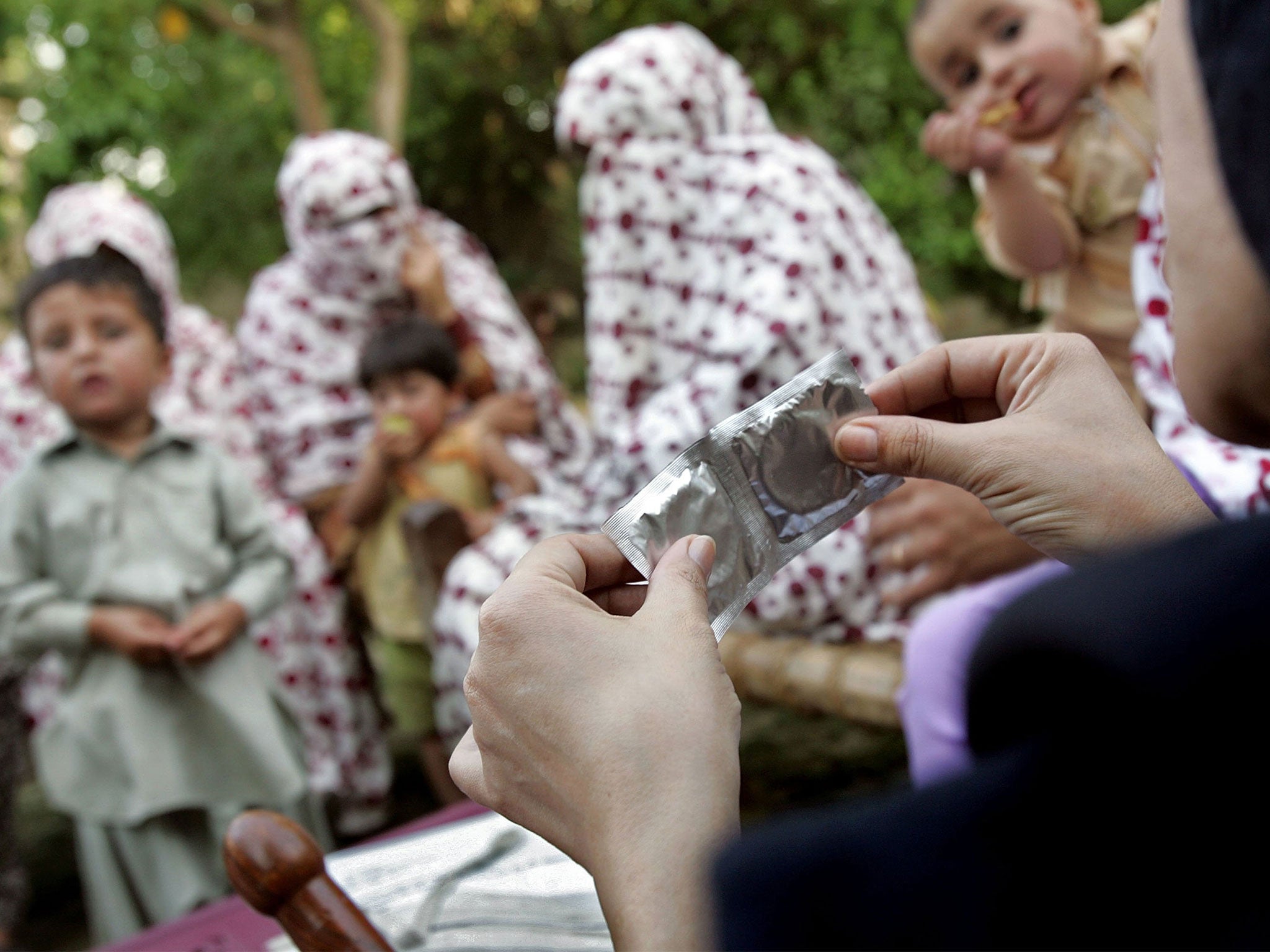 Condoms are shown to a group of women during a safe sex education class in Pakistan