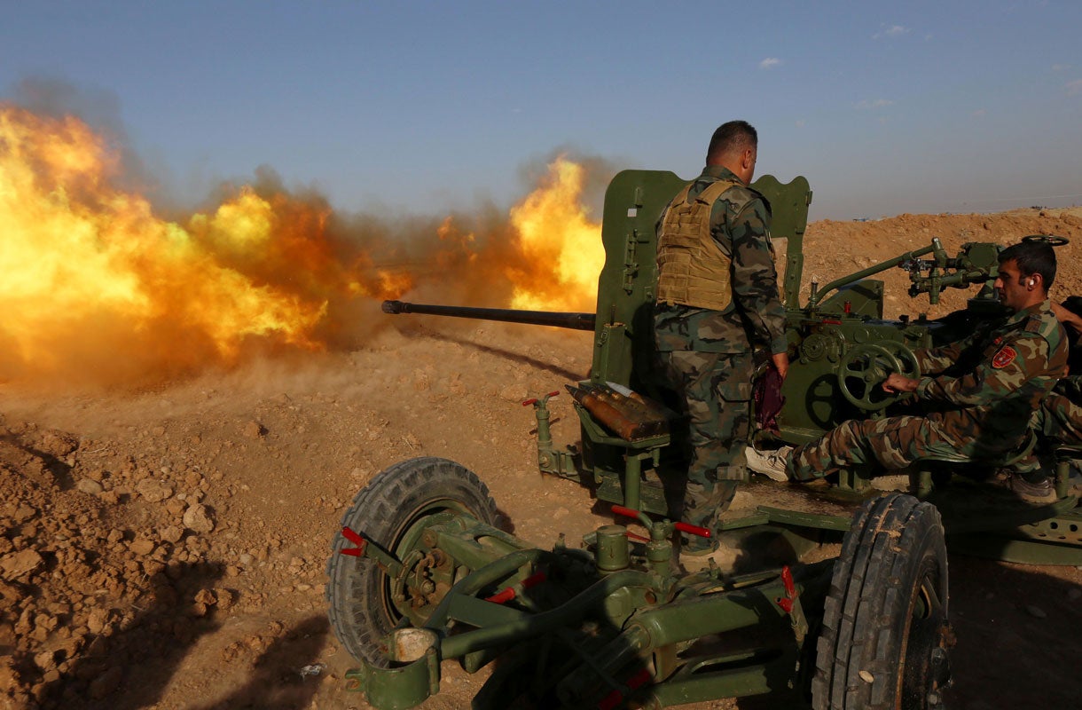 Iraqi Kurdish Peshmerga fighters fire an anti-tank cannon on the front line east of the city of Mosul