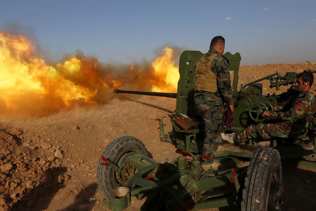 Iraqi Kurdish Peshmerga fighters fire an anti-tank cannon on the front line east of the city of Mosul