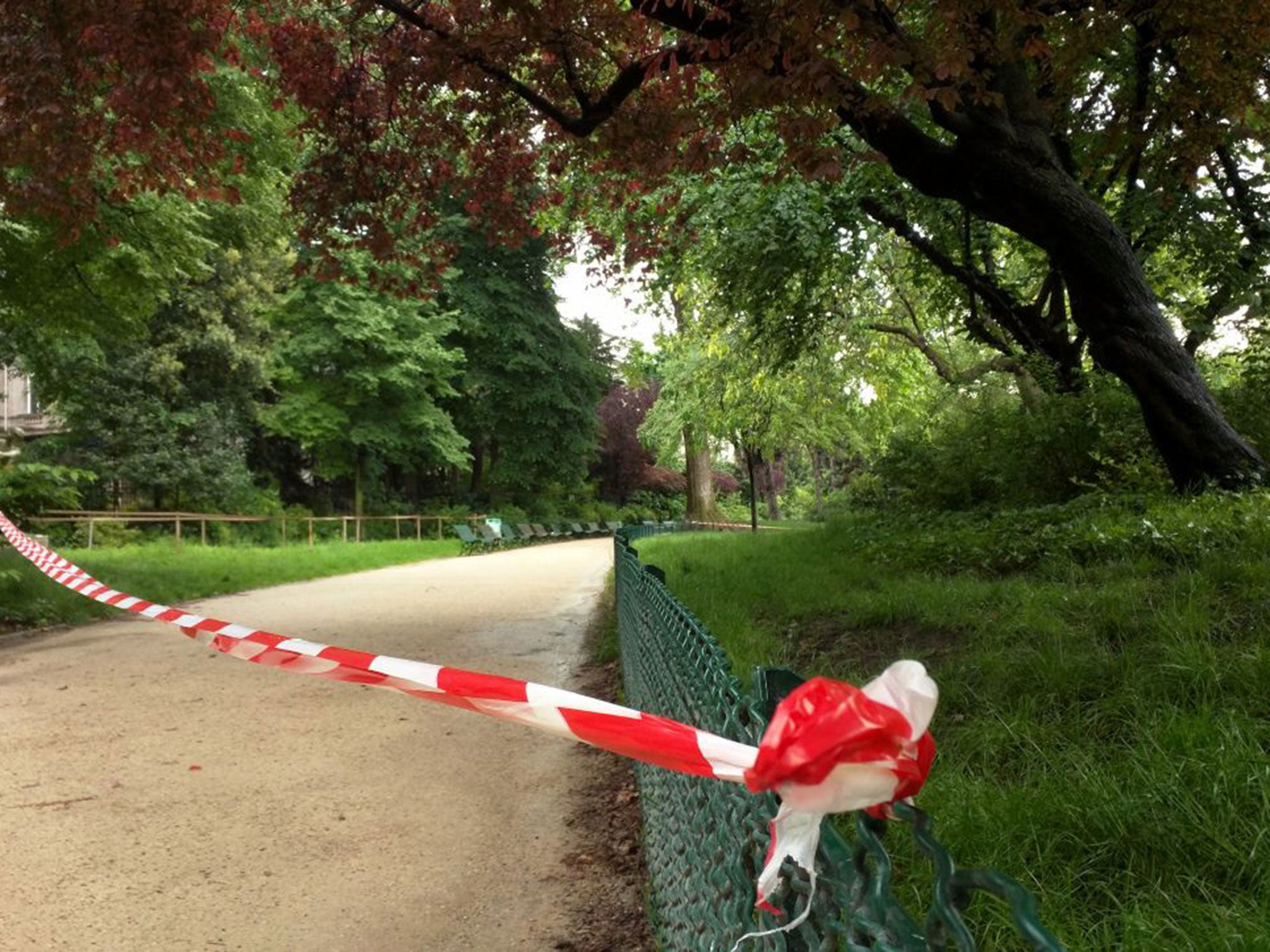 White-and-red tape is strung across a sandy pathway through Paris's Park Monceau after the lightning stike