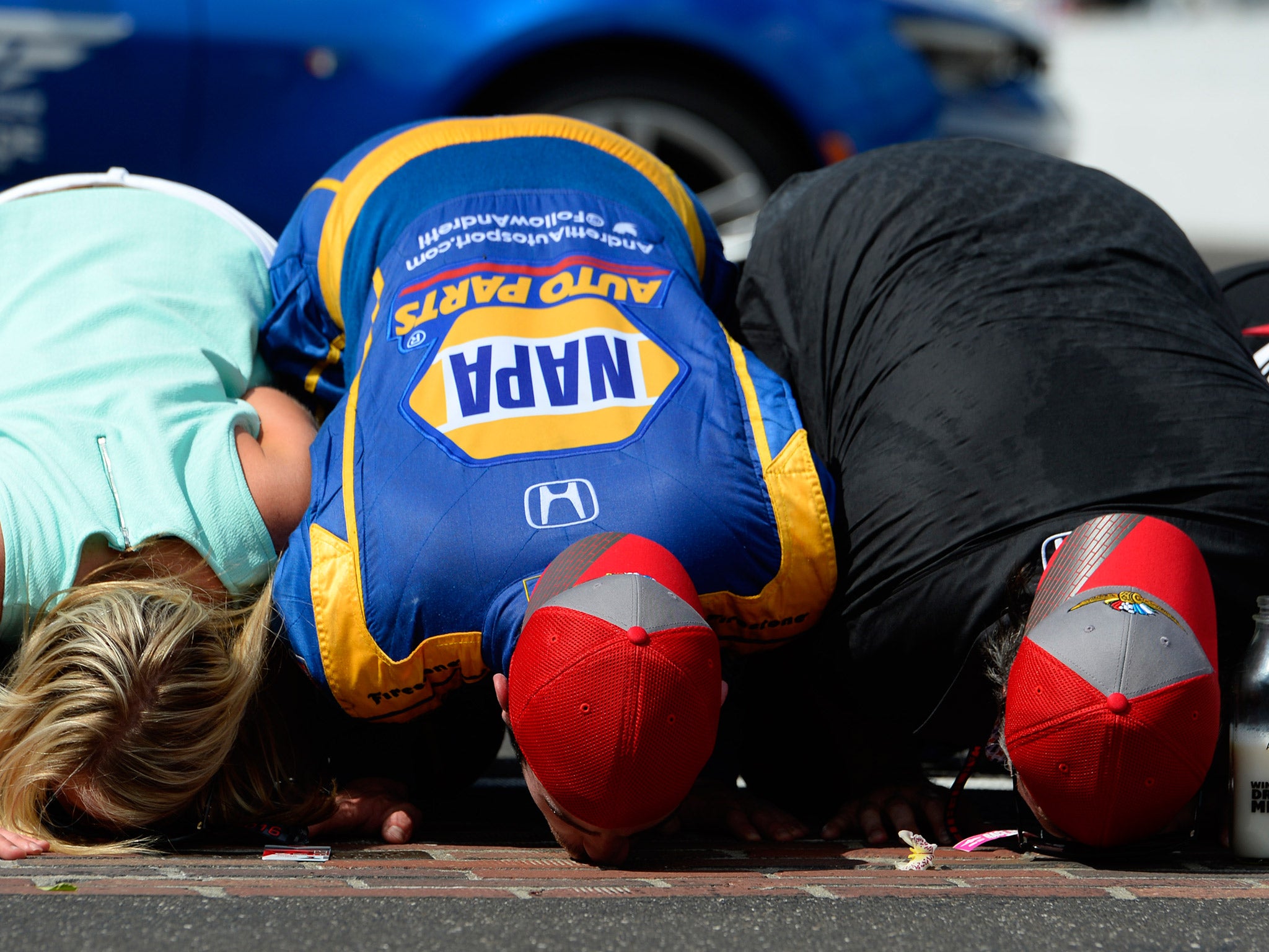 Alexander Rossi kisses the strip of bricks that signal the Indy 500 start line