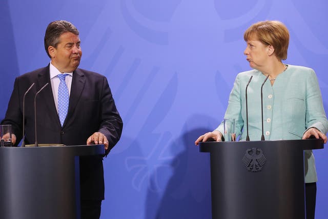 German Chancellor Angela Merkel (R) and German Economy Minister Sigmar Gabriel deliver remarks at a press conference held at the conclusion of a two-day retreat of the German cabinet in Meseberg, Germany