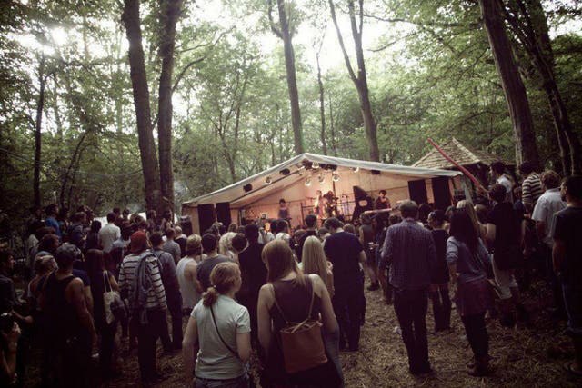 Festival-goers enjoy watching a band play at In the Woods boutique festival in Kent