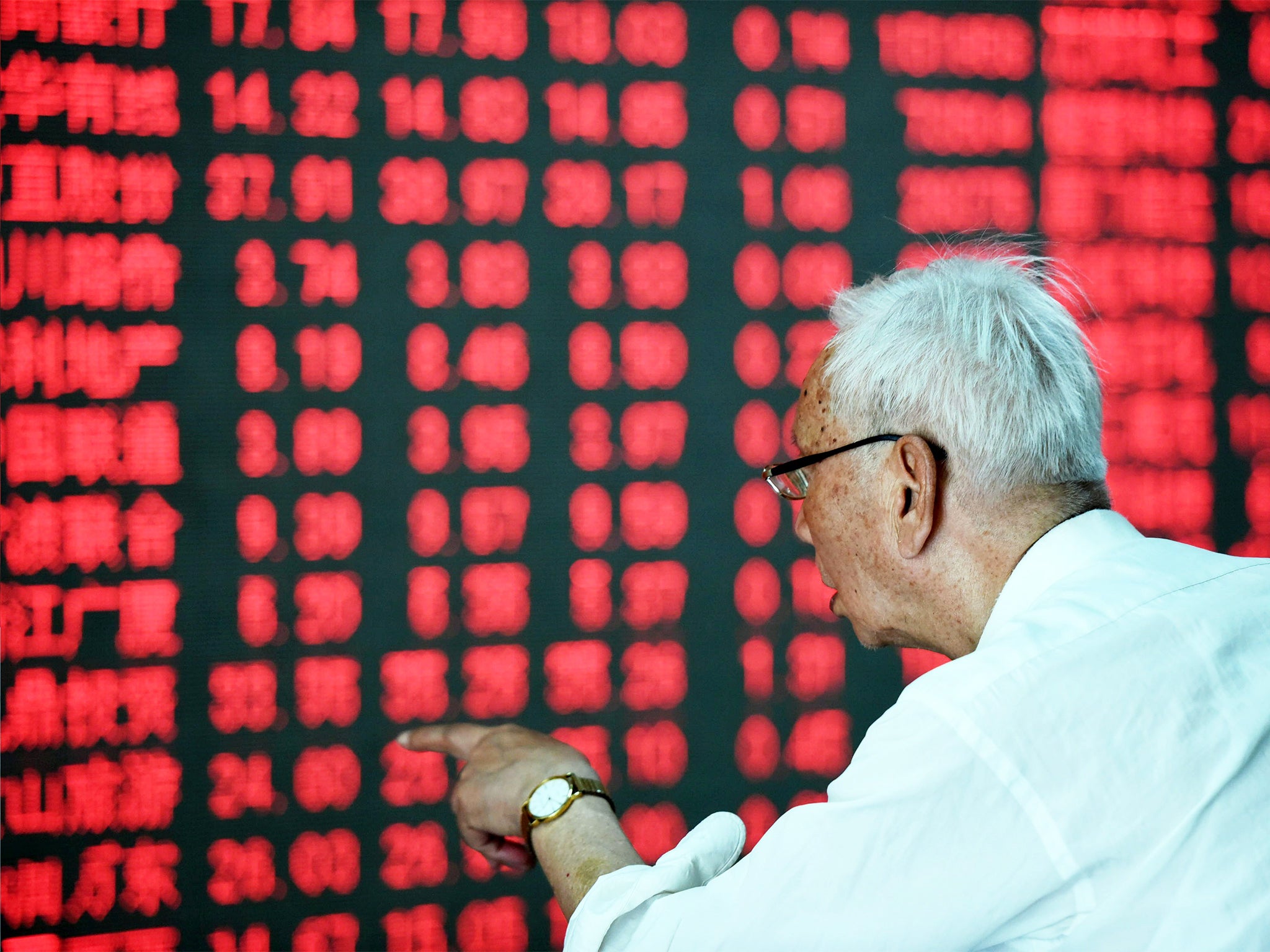 A Chinese investor takes a close look at a screen showing stock market movements in Hangzhou, eastern China, yesterday