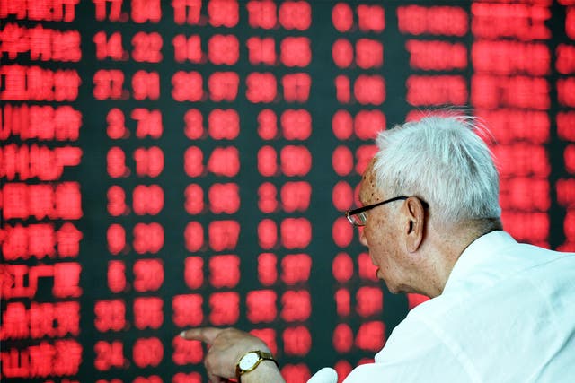 A Chinese investor takes a close look at a screen showing stock market movements in Hangzhou, eastern China, yesterday