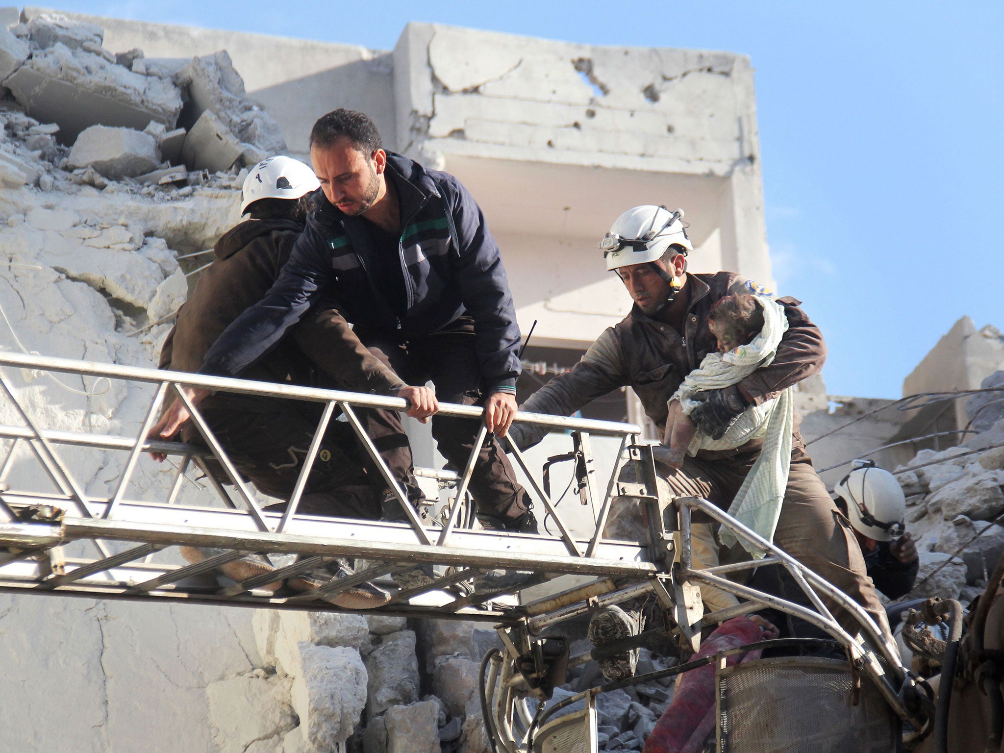 Syrian Civil Defence members evacuate a toddler from the rubble of buildings destroyed following Russian air strikes a day earlier on the northwestern city of Idlib, on May 31, 2016