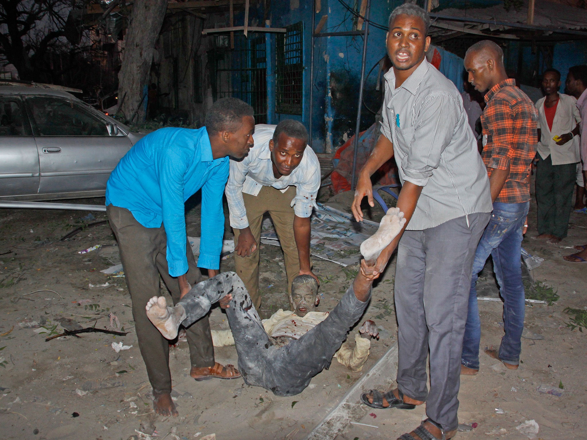 Somali men carry a wounded civilian who was injured in a bomb attack on an hotel in Mogadishu, Somalia, on 1 June 2016