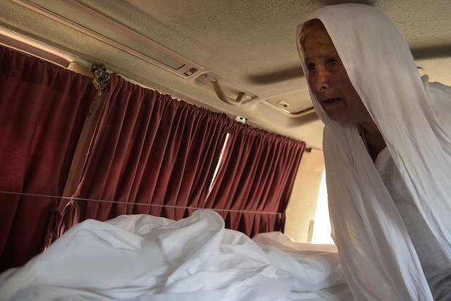 The grandmother of a young woman who was tortured and set alight mourns next to her body in an ambulance outside a hospital in Islamabad on June 1, 2016.