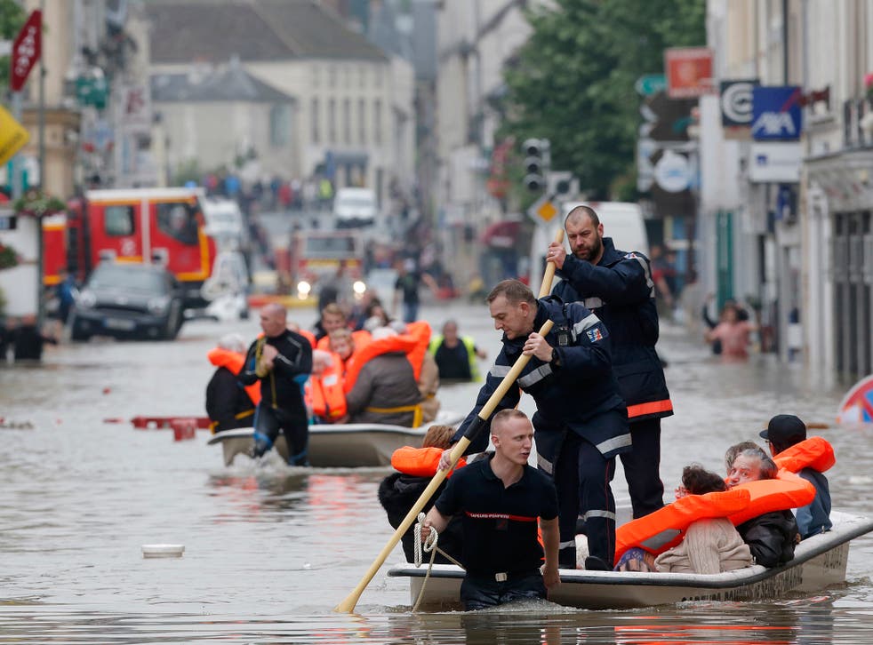 French firefighters evacuate residents from a flooded area after heavy rainfall in Nemours