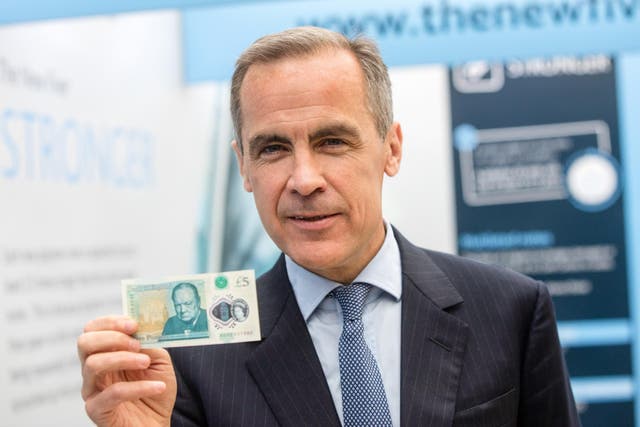 Mark Carney, governor of the Bank of England (BOE), poses for photographers during the launch of Britain's new 5-pound polymer banknote