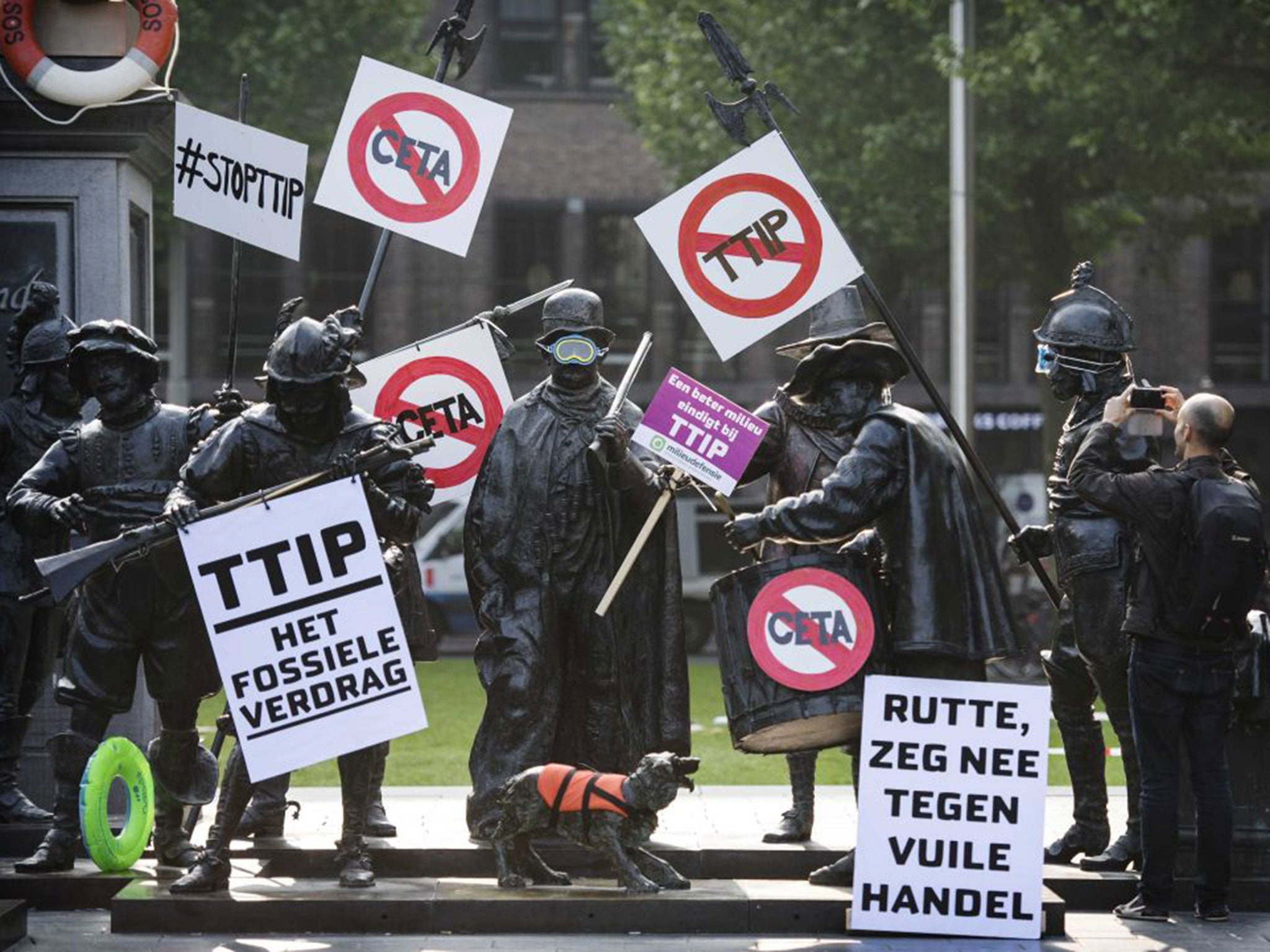 Rembrandt statues are decorated with protest signs during a demonstration against the TTIP trade agreement, in Amsterdam, last weekend