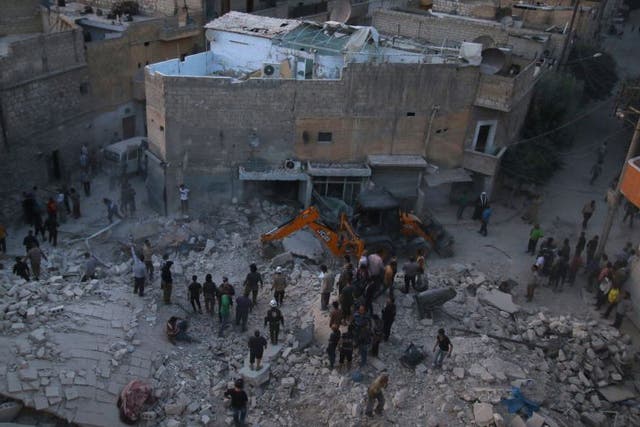 Men inspect damage after an airstrike on Aleppo