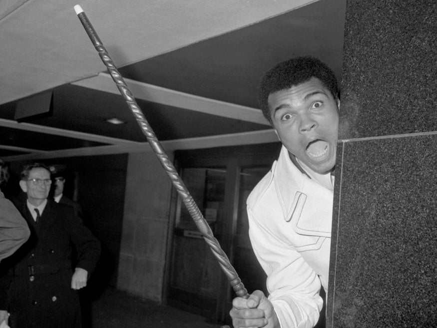 Muhammad Ali as he looks round at the waiting fans as he arrives at Heathrow Airport