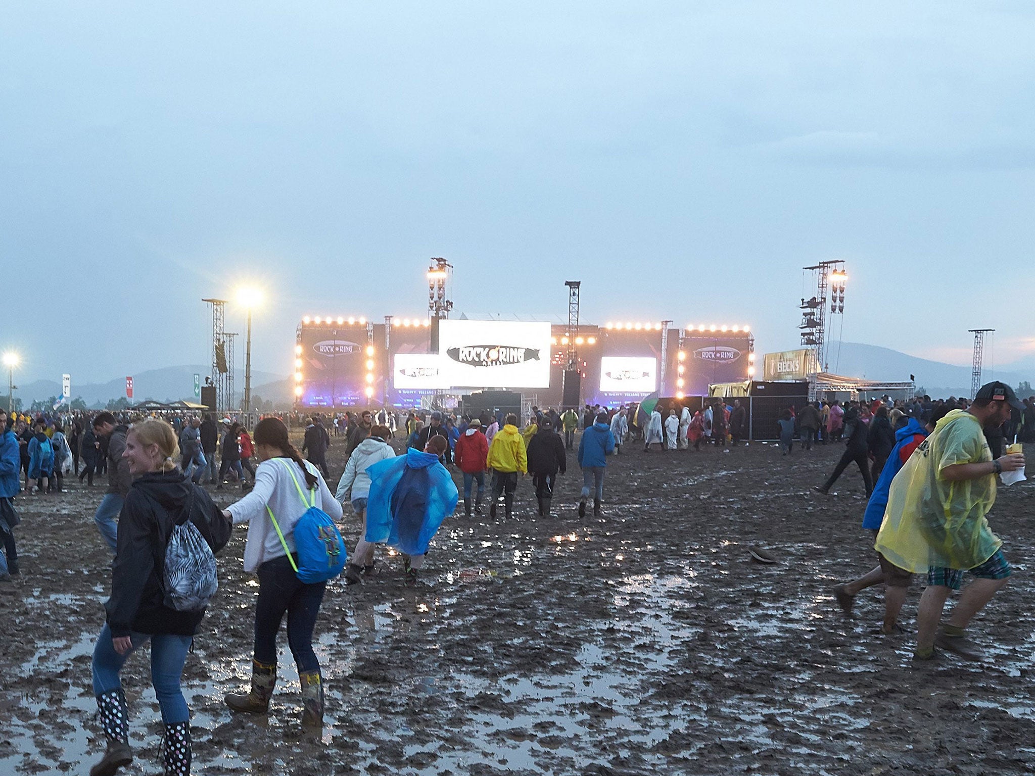 People walk on mud after the venue of the festival 'Rock am Ring' was hit by a storm in Mendig, Germany, 3 June 2016.