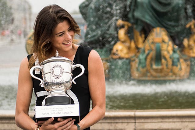A relaxed Garbine Muguruza shows off her French Open spoils in Paris on Sunday (Getty) 
