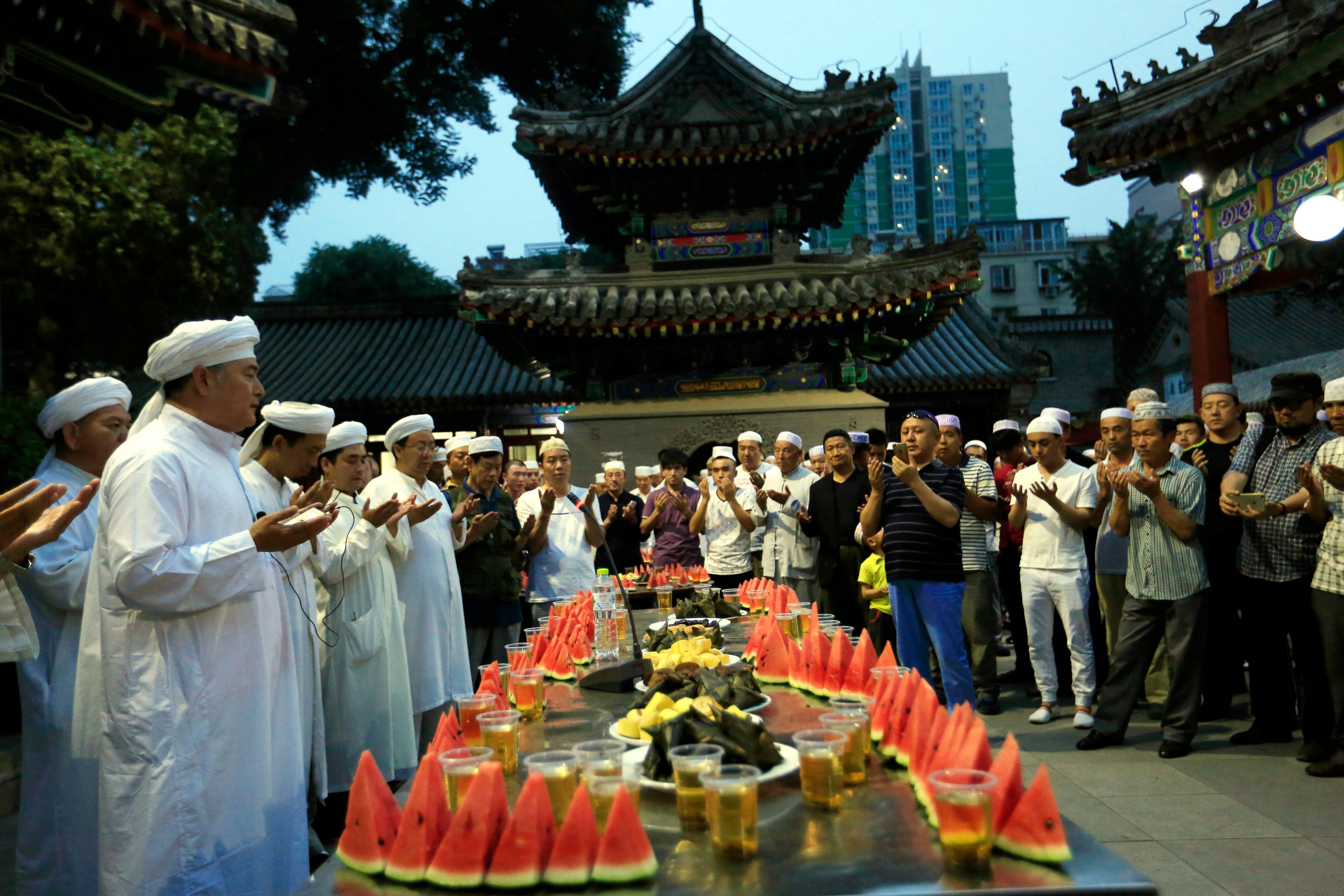 Chinese Muslims pray during a ceremony for breaking fast on the first day of Ramadan at Niujie Mosque in Beijing, China