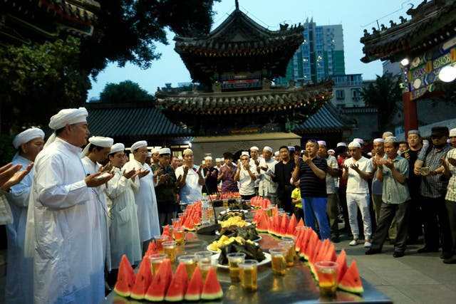 Chinese Muslims pray during a ceremony for breaking fast on the first day of Ramadan at Niujie Mosque in Beijing, China