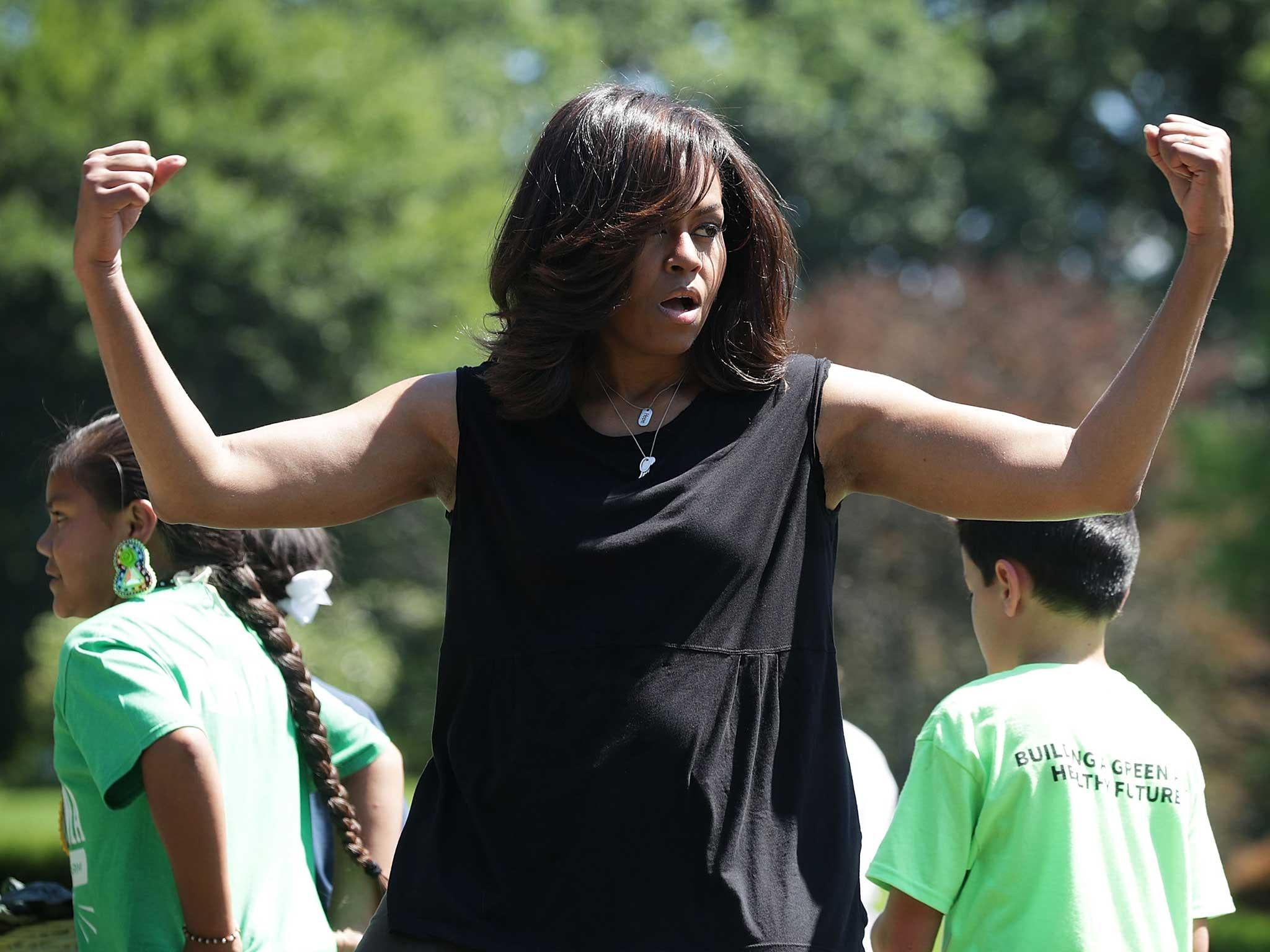 Michelle Obama gestures during a White House Kitchen Garden harvest in Washington. The first lady welcomed back students from the kitchen garden planting earlier in spring to help the harvest