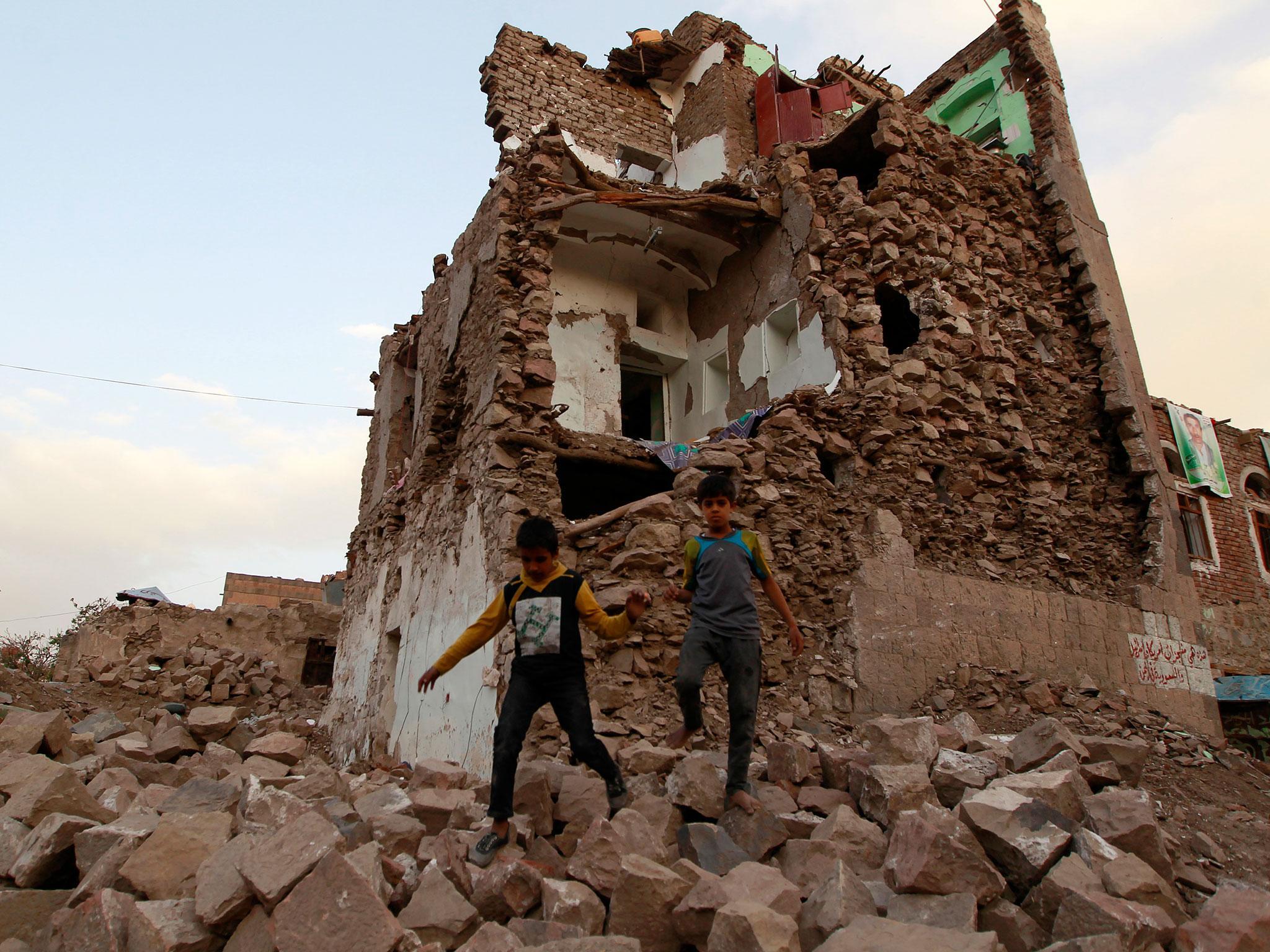Yemeni children walk on stones in front of buildings that were damaged by air strikes carried out by the Saudi-led coalition during the past year in the Unesco-listed old city of the Yemeni capital Sanaa (MOHAMMED HUWAIS/AFP/Getty)