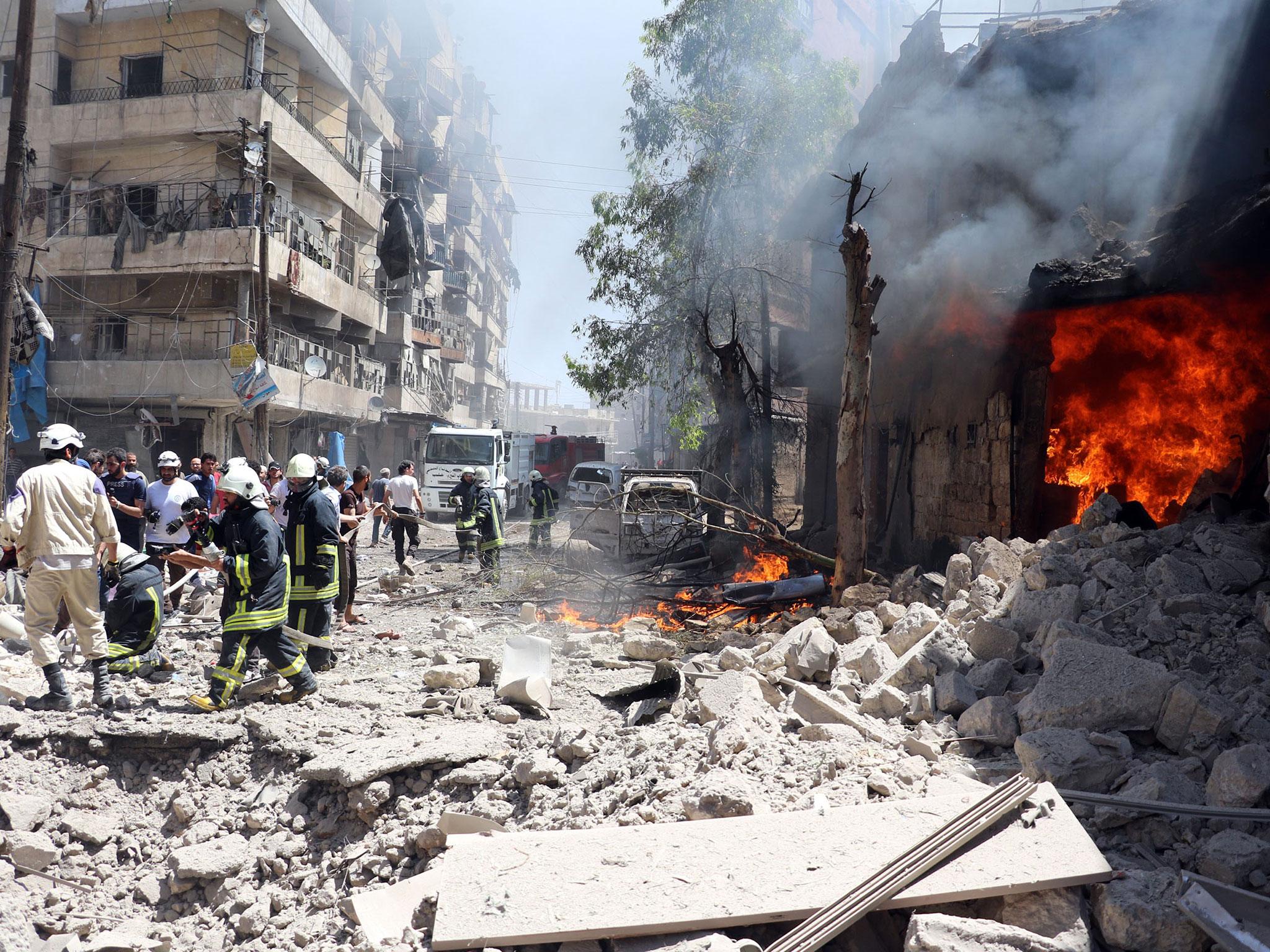 Smoke rises over the wreckage of buildings after a suspected barrel bomb attacks on Beyan hospital and a bazaar in Aleppo, Syria on 8 June, 2016