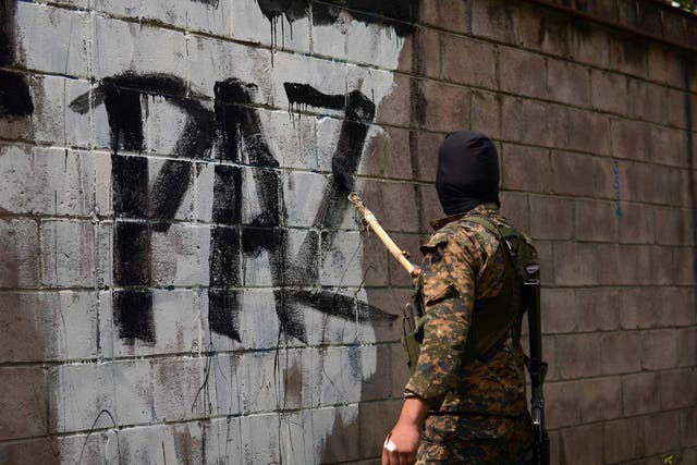  A soldier paints over graffiti associated with the Mara Salvatrucha gang in Quezaltepeque, a town 15 km from San Salvador, in an operation to take back gang-controlled neighborhoods