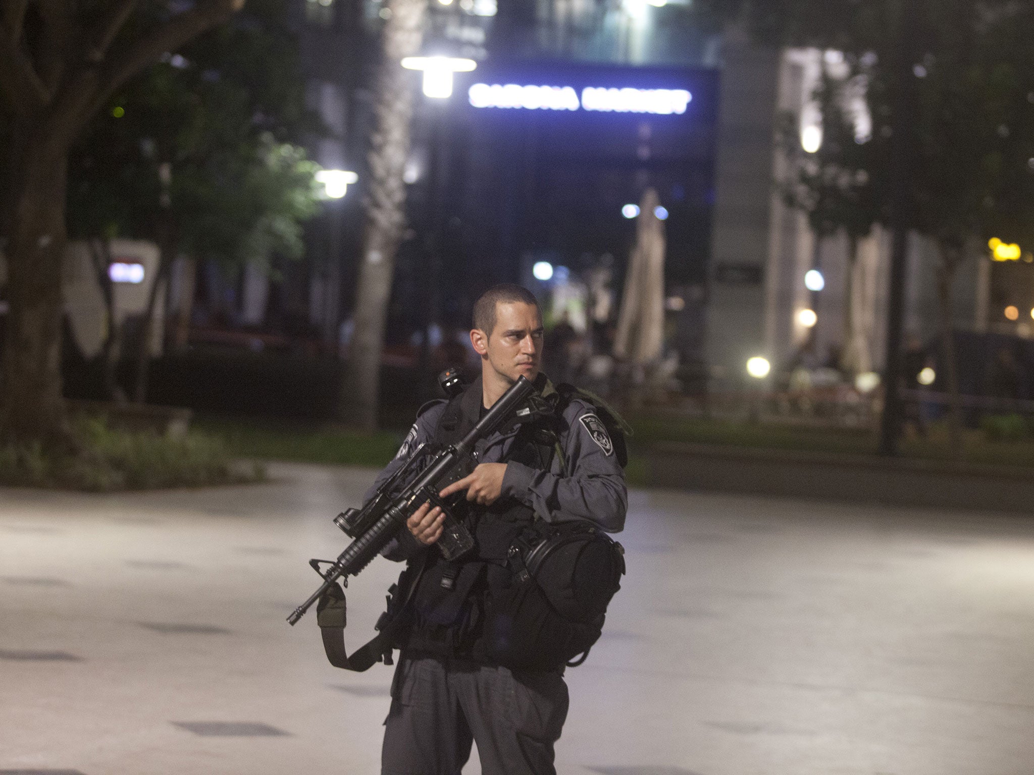 An Israeli Policeman stands at the scene of a shooting outside a restaurant in Sarona Market on June 8, 2016 in Tel Aviv, Israel.