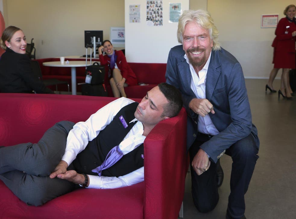 Branson poses next to the sleeping employee