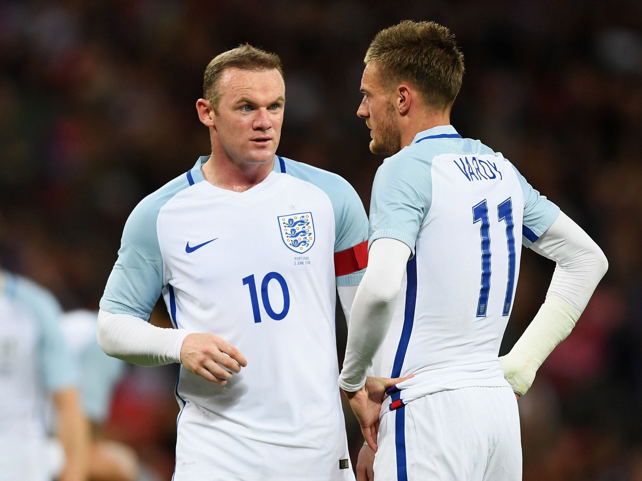 Wayne Rooney talks with Jamie Vardy while representing England