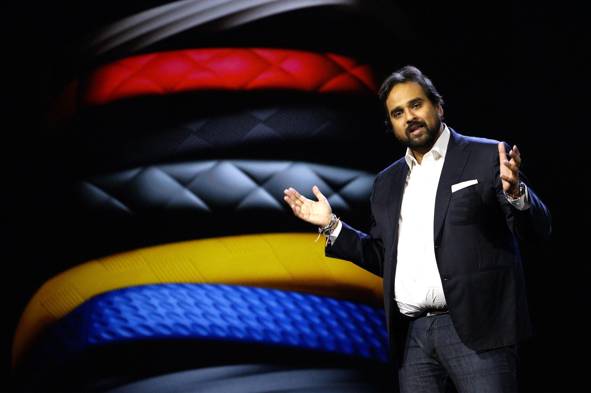 Hosain Rahman, CEO and co-founder of Jawbone, speaks during the Samsung keynote with Jawbone products displayed in the background at the International Consumer Electronics show